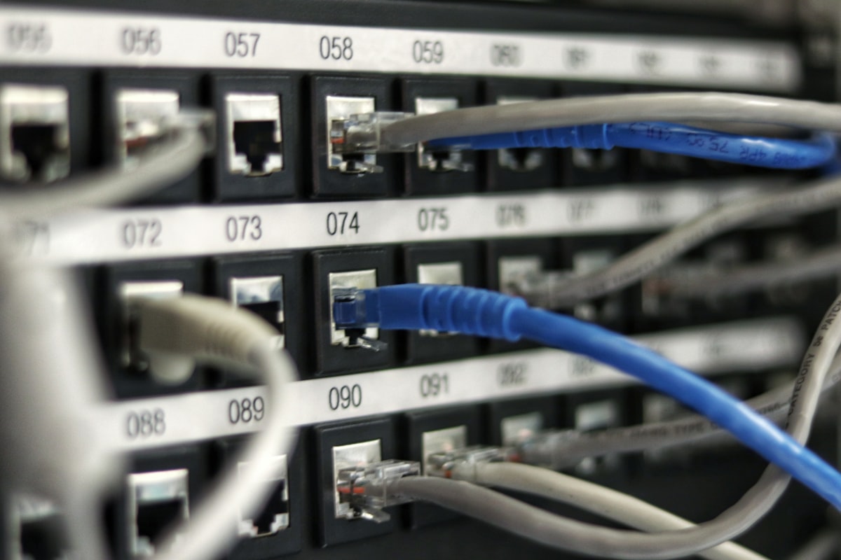 Panel de parcheo con puertos numerados y latiguillos de cobre RJ45
